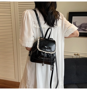 Détail d'un petit sac à dos en cuir PU noir avec bordure dentelle et noeud papillon