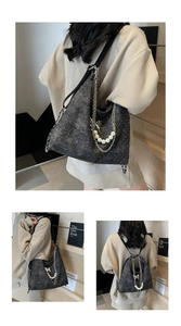 Detail of black glitter tote bag with silver chain, pearls and butterfly charm on shoulder