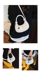 Detail showing the white crescent hobo bag with knotted handle and embossed logo