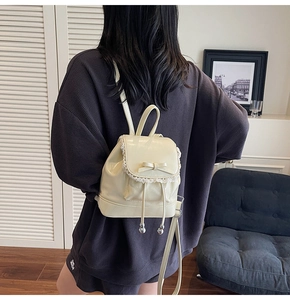 Détail du sac à dos balletcore crème avec dentelle et nœud sur le dos du mannequin