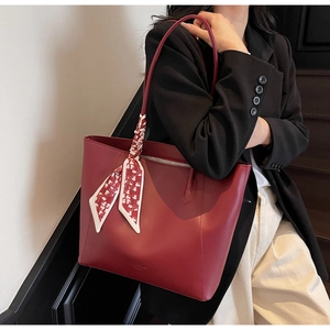 Dunkelrote Leder-Tote-Bag mit dekorativem Herzschal am Griff im Detail