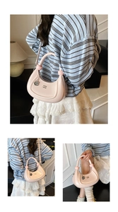 Detail view of pink crescent bag with metal ring handle and branded G pendant