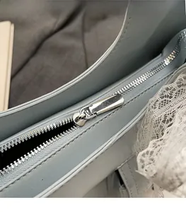 Dettaglio macro della cerniera in metallo argento su una borsa azzurra moda