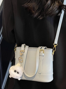Chic light blue leather bucket bag for women with plush charm and gold hardware