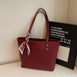 Elegante weinrote Leder-Tote-Bag mit Seidenschal und goldenen Nietendetails am Griff