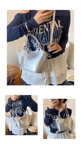 Detail of silver textured bucket bag with pearl charm and adjustable shoulder strap
