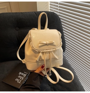 Détail d'un sac à dos beige style balletcore avec dentelle, nœud et cordon de serrage