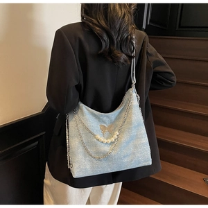 Detail of light blue sequin tote bag featuring pearl chain and butterfly metal clasp