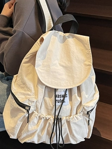 Beige nylon drawstring backpack with adjustable straps and front zipper pocket