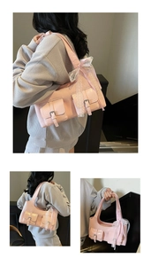 Dettaglio borsa sottobraccio rosa con fiocco di pizzo e doppie tasche con fibbia