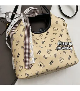 Detail showing beige printed tote with cartoon bears, black handles and lace bow accent