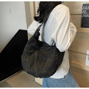 Detailed view of black denim tote bag with yellow contrast stitching and side pockets