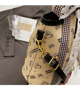 Close-up of golden metal buckle and black leather trim on a printed tote bag
