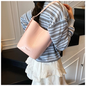 Close-up of pink crocodile pattern bucket bag with fashion leather embossing details