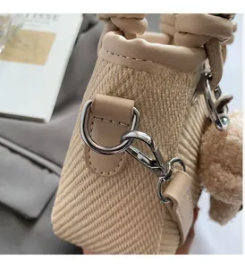 Detailed close-up of premium silver hardware and woven texture on beige bucket bag