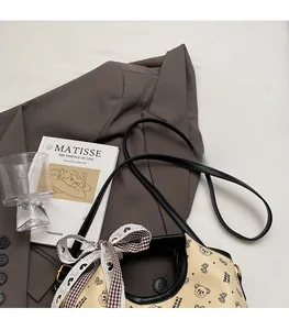 Detail of adjustable shoulder strap and cute bear print on beige large tote bag