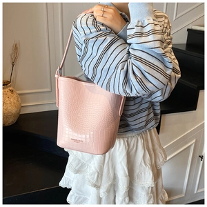 Detail of light pink crocodile pattern bucket bag with fashion and bags leather print