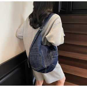 Detail view of large capacity denim crossbody bag with double front utility pockets