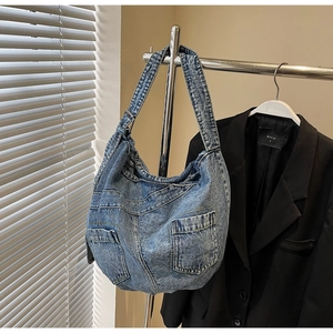 Close-up of retro washed denim hobo bag with decorative pockets and visible stitching