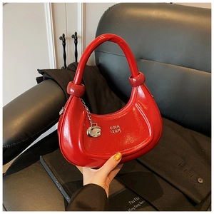 Detail of red glossy crescent hobo bag with silver G-pendant and brand logo