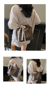 Detailed view of brown tote bag with bear pattern and black and white ribbon detail