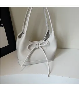 Close-up of cream white PU shoulder bag with soft texture and elegant bow detail