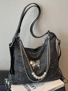 Women's black tote bag with white polka dots, silver butterfly charm and pearl chain