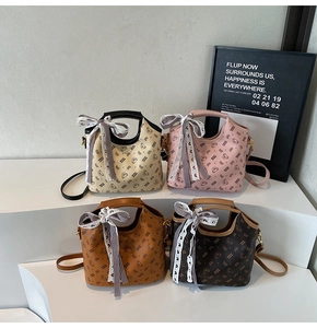 Detail of four stylish bucket bags with bear patterns and plaid ribbon decorations