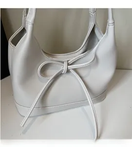 Detailed top view of a cream PU leather tote bag with a stylish bow decoration