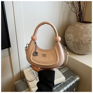 Detail of pink crescent bag with gold G pendant, stylish hardware and smooth texture