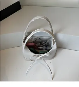 Detailed view of the white PU leather tote interior showing spacious storage and bow detail
