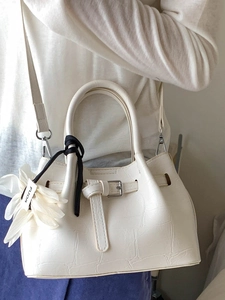 Elegante weiße Beuteltasche mit Krokodilprägung, Blumenanhänger und Umhängeriemen