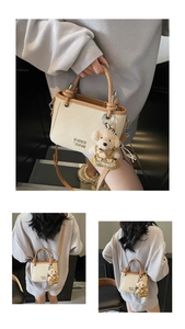 Detail of straw woven bucket bag with leather trim and cute bear charm for daily wear