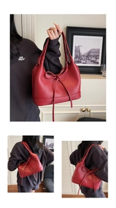 Detail of red PU leather tote bag featuring a large decorative bow and matte finish