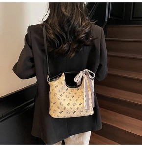 Classic beige tote bag with bear print and plaid bow detail shown on a model