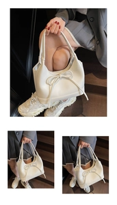 Detailed close-up of a minimalist cream PU tote bag with elegant bow knot decoration