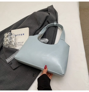 Vista laterale dettagliata della borsa hobo azzurra in pelle liscia con cuciture rifinite