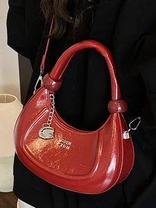Chic red patent leather crescent handbag with a silver metal chain and letter charm