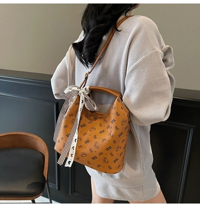 Classic brown leather tote bag with bear print and decorative silk scarf detail