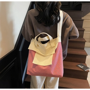 Red and white checkered canvas tote bag with side pockets shown in use on a wooden staircase