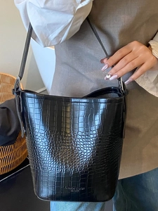 Women's black crocodile pattern bucket bag with adjustable shoulder strap for daily commuting