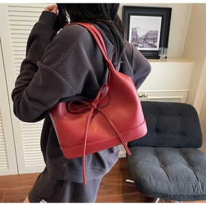 Model view of red PU leather tote bag with bow detail and minimalist design