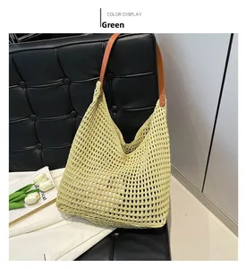 Detail of green woven hollow tote bag with brown leather handle on black bench