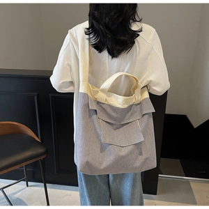 Detail of blue and white striped canvas tote bag with functional front flap pocket