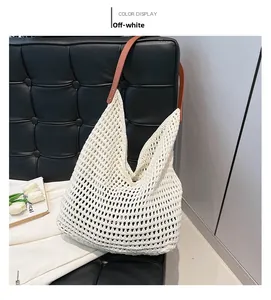 Detail of hollow woven shoulder bag in beige cotton cord with brown leather strap