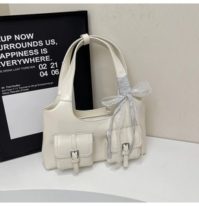 Dettaglio borsa tote bianco crema in PU con tasche a fibbia e nastro di pizzo