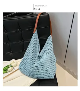 Close-up of light blue crochet shoulder bag with brown leather strap on a black chair