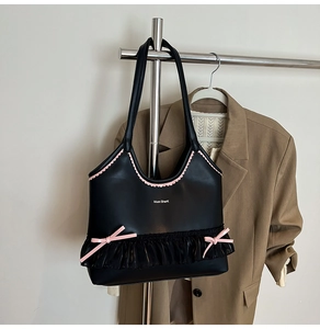 Detail view of the black Balletcore tote bag with pink bows and mesh ruffles hanging