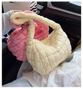 Detalle del bolso acolchado tipo nube en rosa y crema con costuras en forma de rejilla