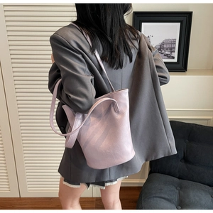 Detail shot of light purple crocodile embossed bucket bag with adjustable strap